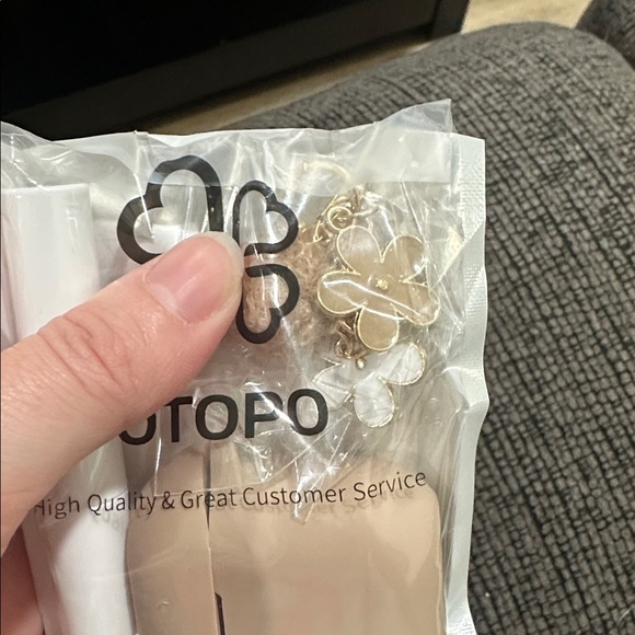 Beige AirPod 4 case with flower keychain and AirPod cleaner - Picture 2 of 2